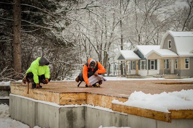 Despite the cold and snowy conditions, site contractors plot the lines of just one of the 42 new homes rising up from the earth at 2080 Union. 