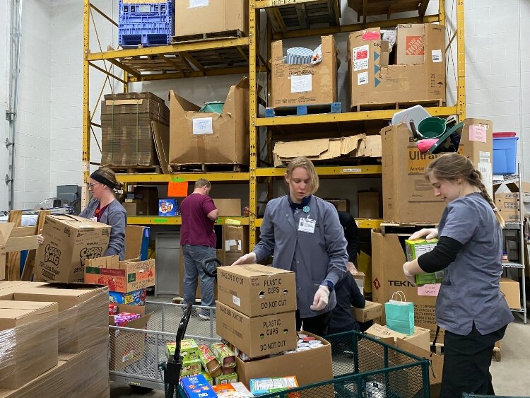 Love In Action staff sort food donations. 