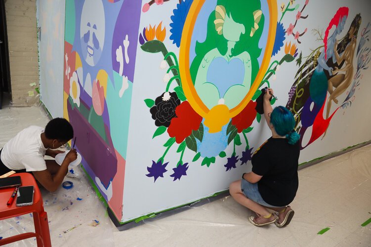 Alyssa Macek and Anaïs Adjahi work on their murals.