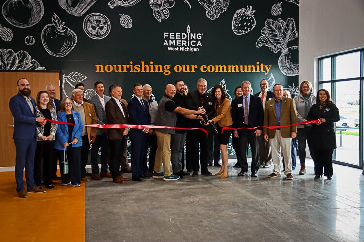 Feeding America WM's president and CEO, Ken Estelle, is joined by members of his team and board and area leaders who made this new facility possible.