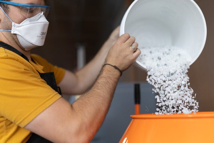 Jared Seifert of Design Declassified prepping shredded plastic waste for the next step in Design Declassified's production process.