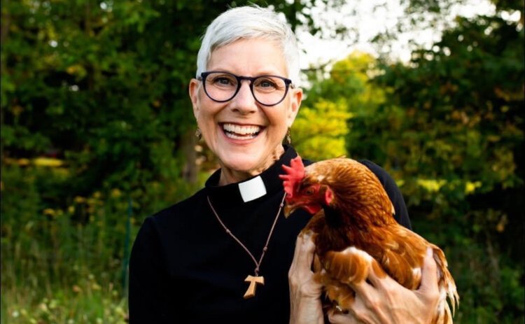 The Rev. Ginny Mikita poses with a chicken.