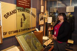 Katrina Furman, the newly appointed Anishinaabe curator and member of the Grand Traverse Band of Ottawa and Chippewa Indians looks into an exhibit that features the flag of her people as well as a ballot that bear the names of one of her ancestors.