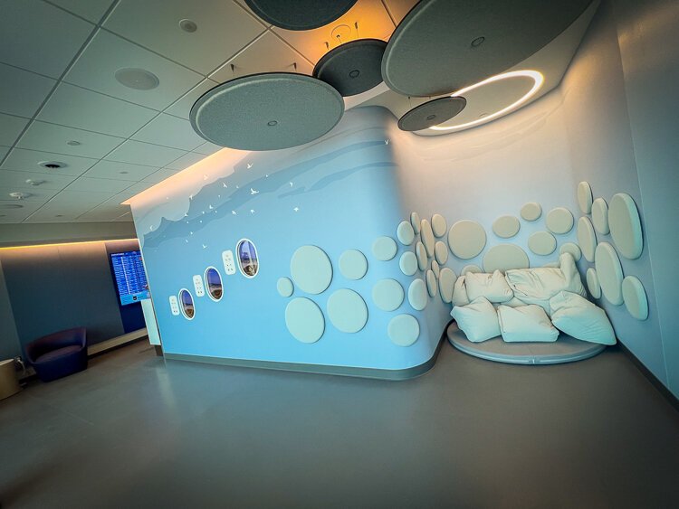 HKS' designed this space with soft, sound-absorbing round panels to guide neurodivergent travelers to this cloud-like area, where weighted pillows offer comfort and calm while folks soak in natural light.