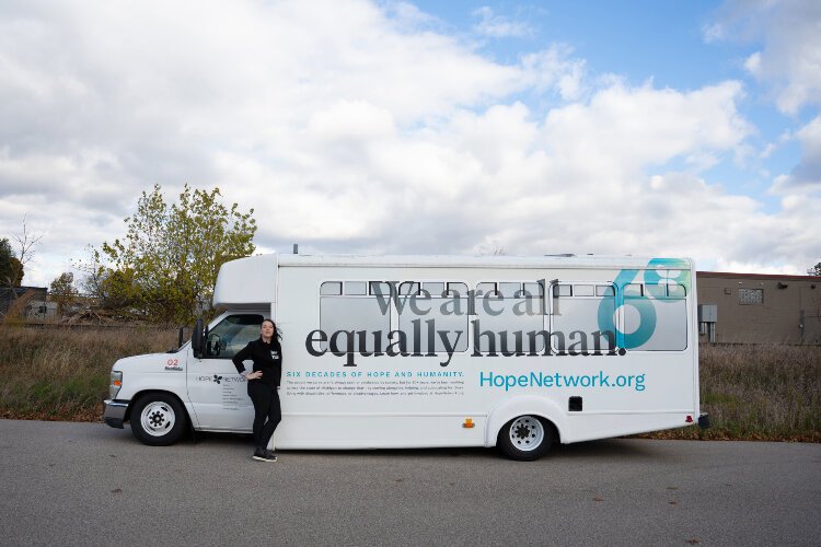 Hope Network's first Chief Advancement Officer Jaime Counterman poses with the nonprofit's bus.