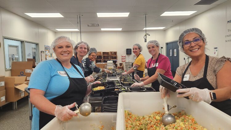 A team of volunteers works together to plate meals for seniors who receive MOWWM's Home Delivered Meals.