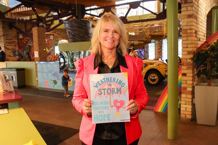 Vonnie Woodrick, founder of i understand, holds a coloring book designed to help children process emotions.