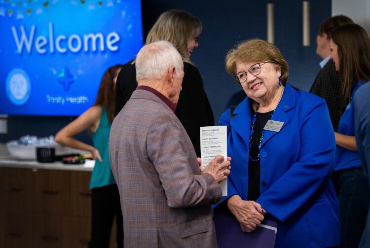 Linda Lewandowski, dean of the Kirkhof College of Nursing, right, speaks with Muskegon Community College board trustee Don Crandall, left, during an event at Trinity Health Muskegon Hospital celebrating the nursing partnership Oct. 29.