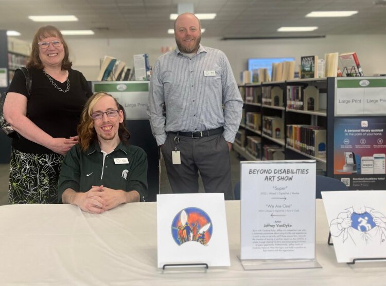 Beyond Disability Art Show at the Muskegon Area District Library’s Library for the Visually and Physically Disabled. Pictured from left to right: Janet Perreault, Jeff VanDyke, and Brad Hastings (artwork by Jeff VanDyke).