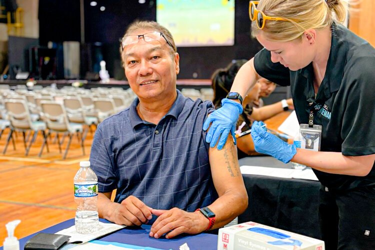 A man receives a COVID-19 vaccination clinic at the Burma Center. 