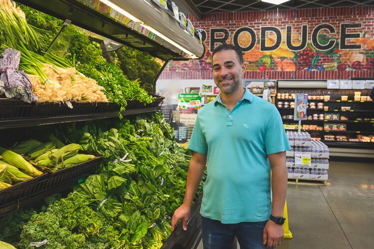 Vincent Nona stands in the produce section of Parkway Foods store.